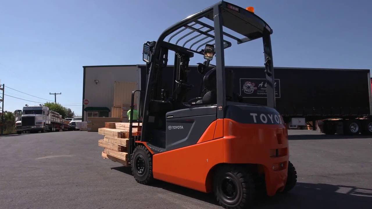 Chariot élévateur Toyota transportant des planches de bois à travers un terrain en bois 