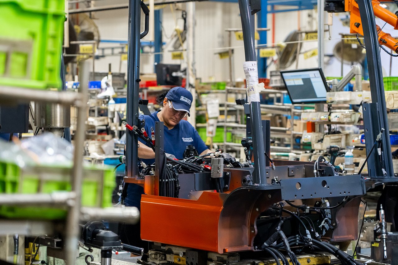 Female technician working on forklift machinery